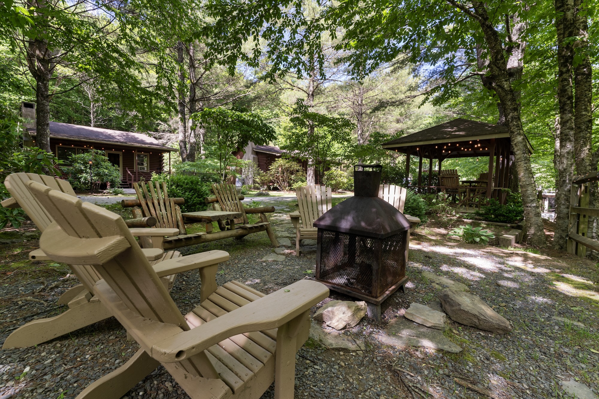 Alpine Village Resort common area with Adirondack chairs, fire pit, gazebo, and cabin